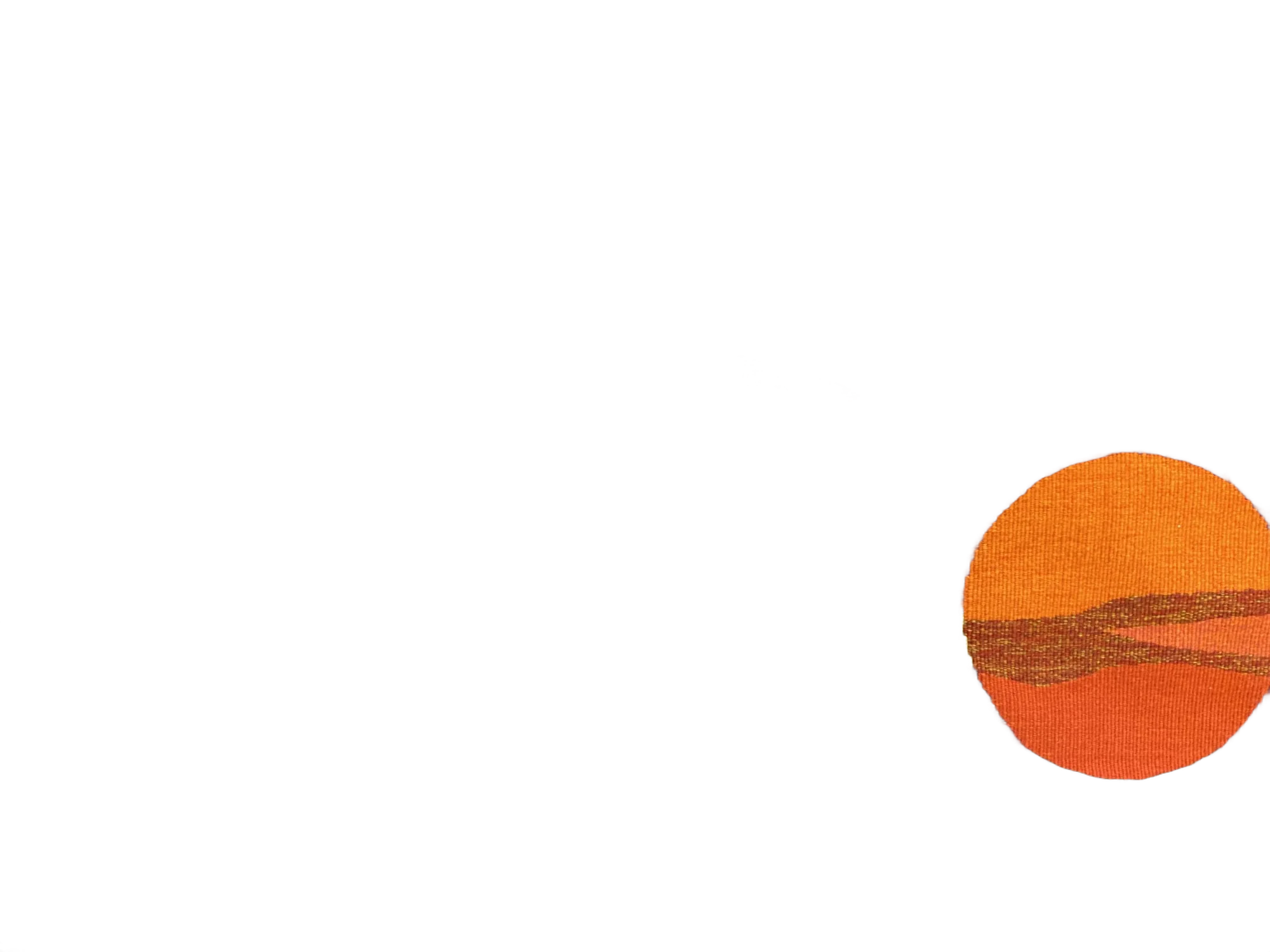 Tapisserie tissée abstraite représentant un coucher de soleil orange sur des nuages jaunes, rouges et bruns, posée sur un sol en béton, avec une petite signature en forme de poisson en haut à gauche.